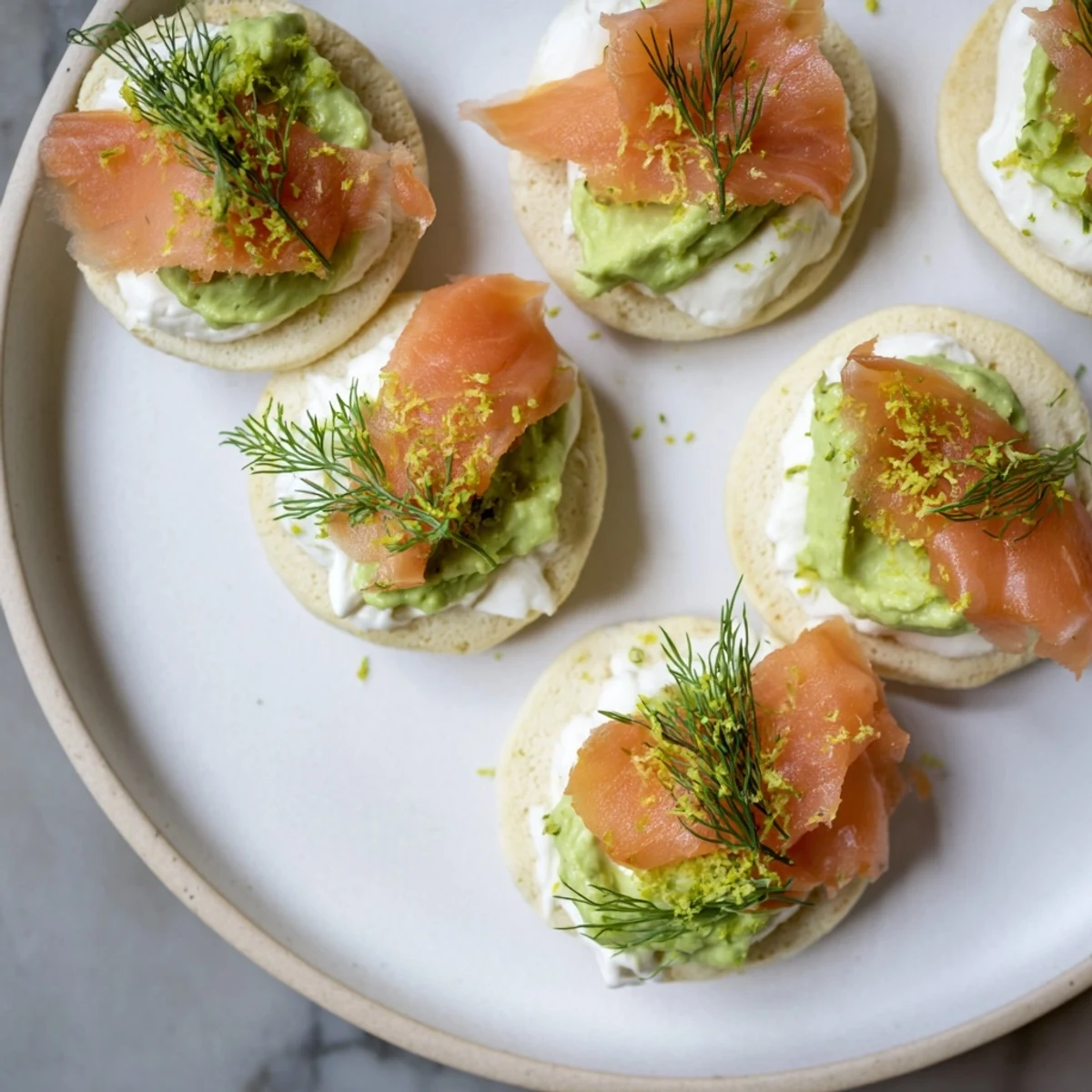A close-up of quark blinis: golden brown, topped with salmon, avocado, ready for brunch.