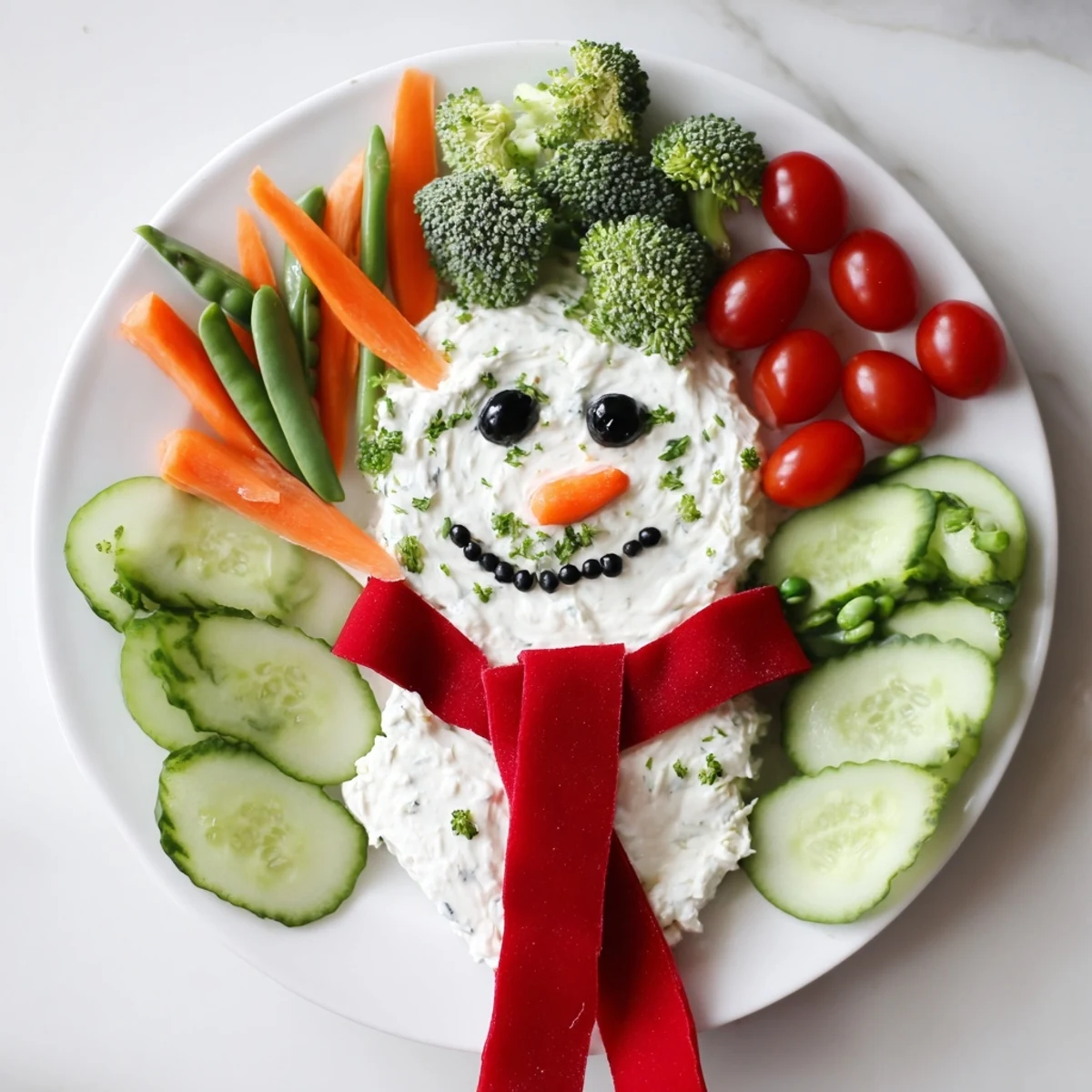 Festive snowman veggie dip platter, featuring a creamy dip snowman surrounded by vibrant, fresh vegetables.
