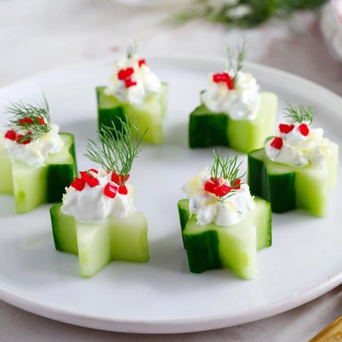 Festive Cucumber and Dill Christmas Stars appetizer, beautifully garnished with fresh dill and red pepper.