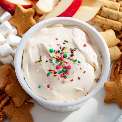 Creamy gingerbread house dip board surrounded by gingerbread cookies, a delicious holiday dessert.