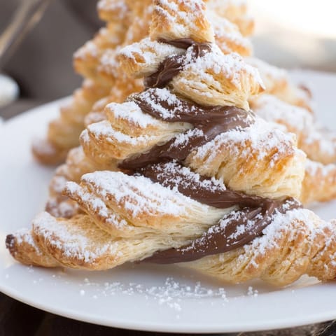 Golden brown Nutella Pastry Christmas Trees, baked till flaky, dusted with powdered sugar, ready to eat for the holidays.