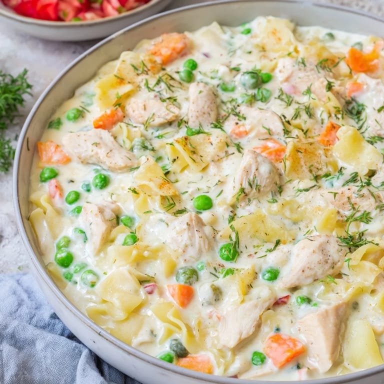 A steaming bowl of comforting Chicken Pot Pie Pasta Soup, filled with tender chicken and veggies.